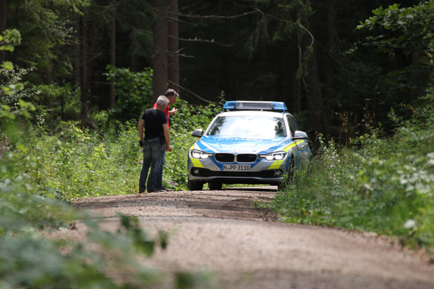  Picture shows two men talking to two policemen sitting in a police car and informing them about the theft of their car.