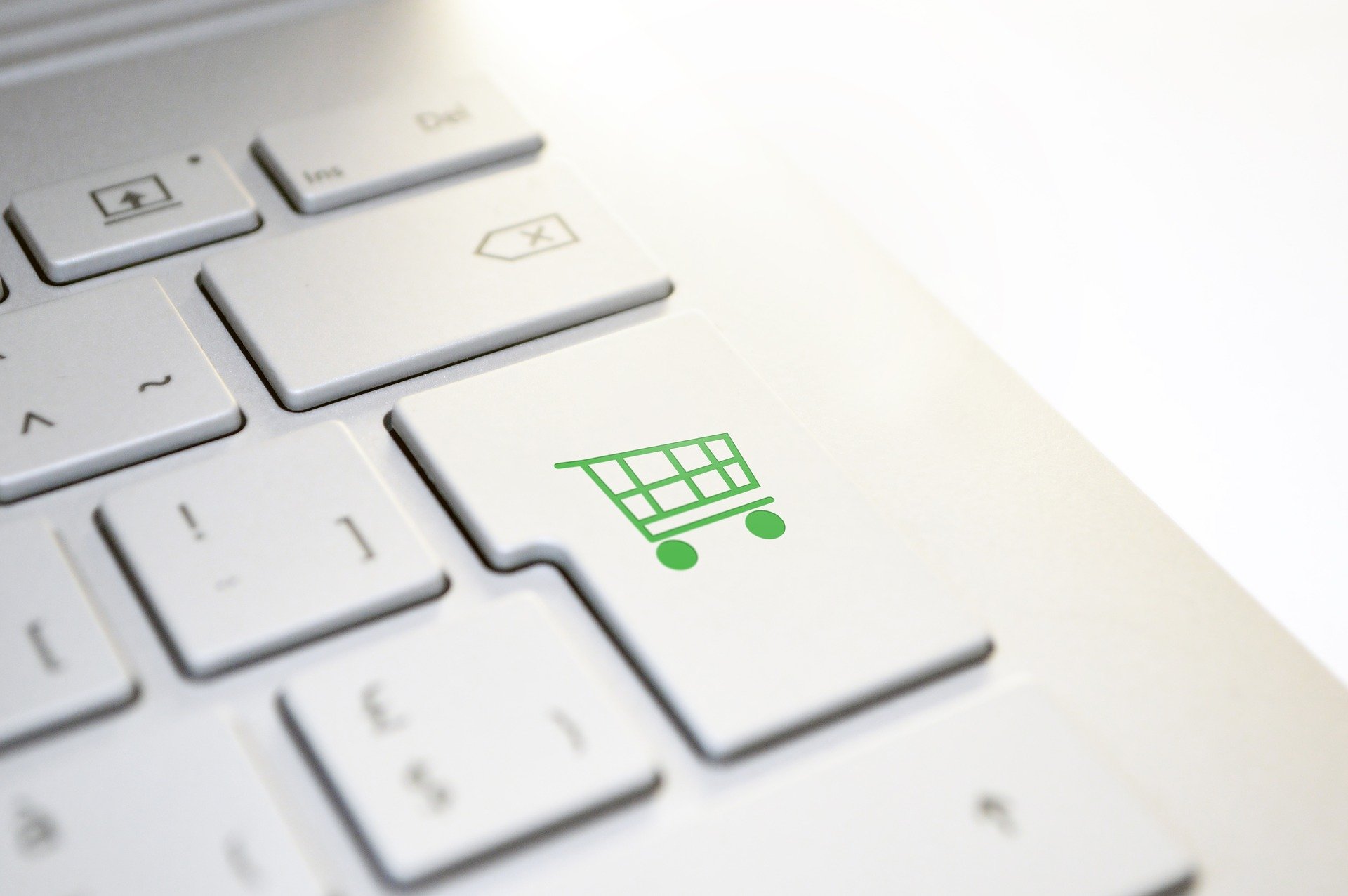 Cutout of a computer keyboard with a shopping cart icon as a representation for buying spare parts online