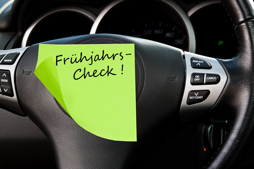 Steering wheel with a PostIt with the inscription: Spring check
