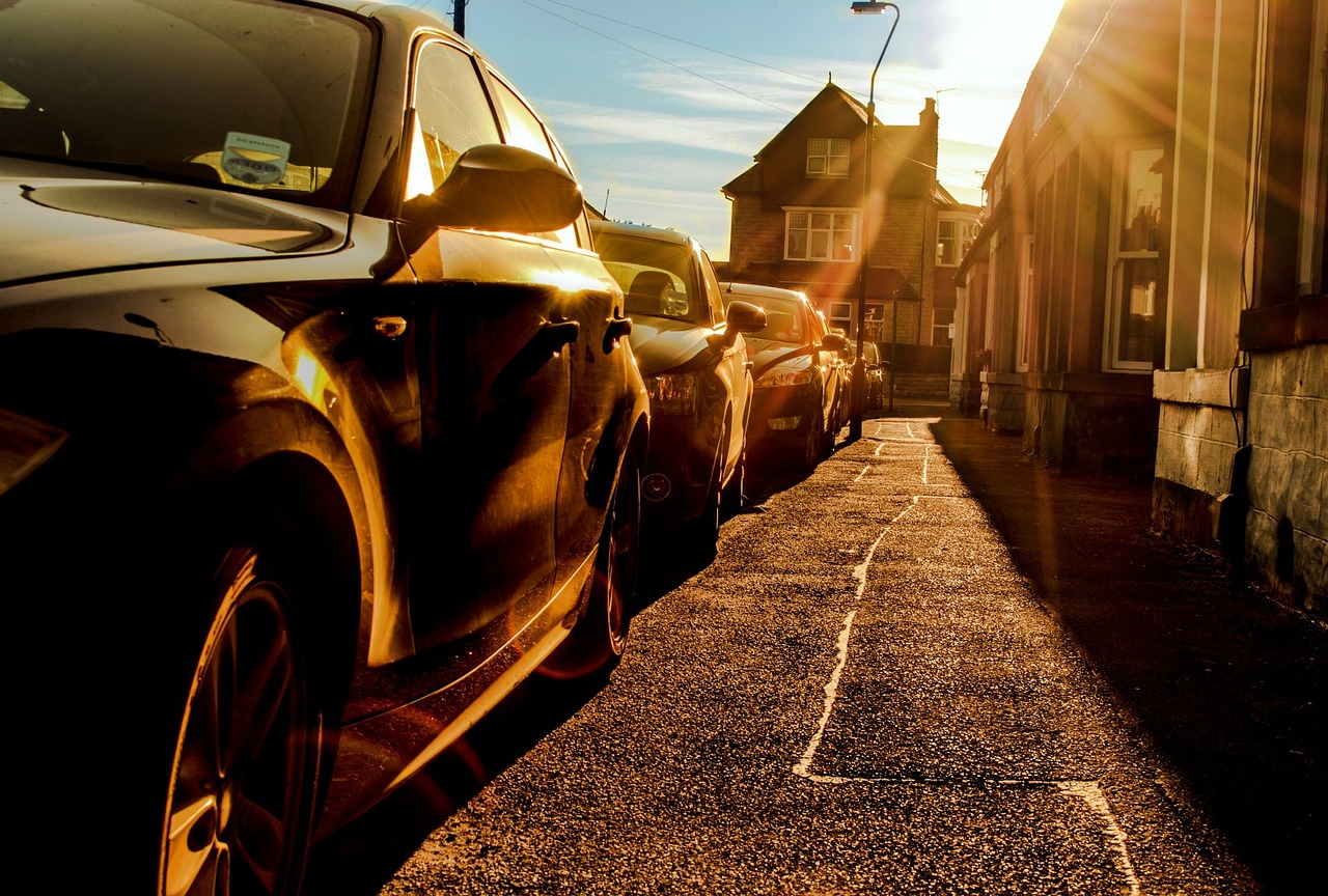Parking cars on the road in the shimmering sun as a symbol of heat in the car