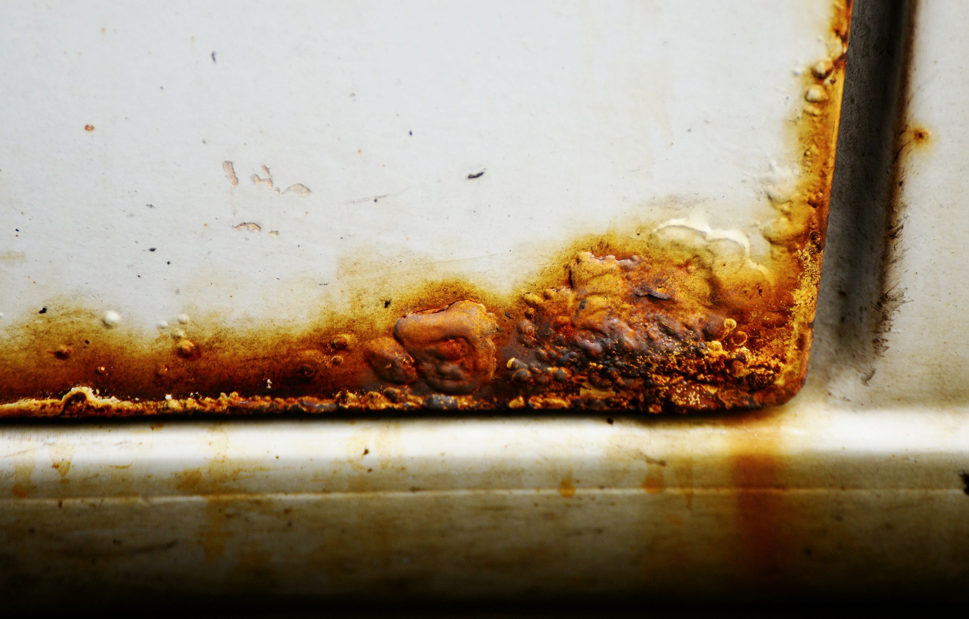 The picture shows a part of a car door with rusty spots